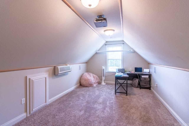 carpeted home office featuring an AC wall unit and vaulted ceiling