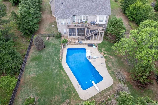 view of pool featuring a patio, a diving board, a lawn, and a wooden deck