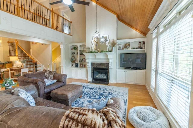 living room featuring light hardwood / wood-style flooring, high vaulted ceiling, decorative columns, wood ceiling, and ceiling fan with notable chandelier