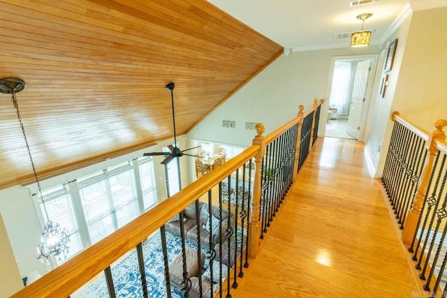 hallway with ornamental molding, wood ceiling, lofted ceiling, and light wood-type flooring