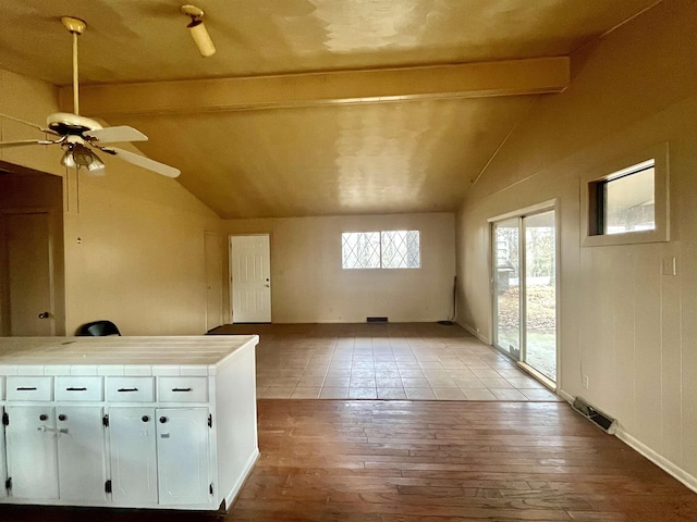 additional living space with vaulted ceiling with beams, light hardwood / wood-style floors, and ceiling fan