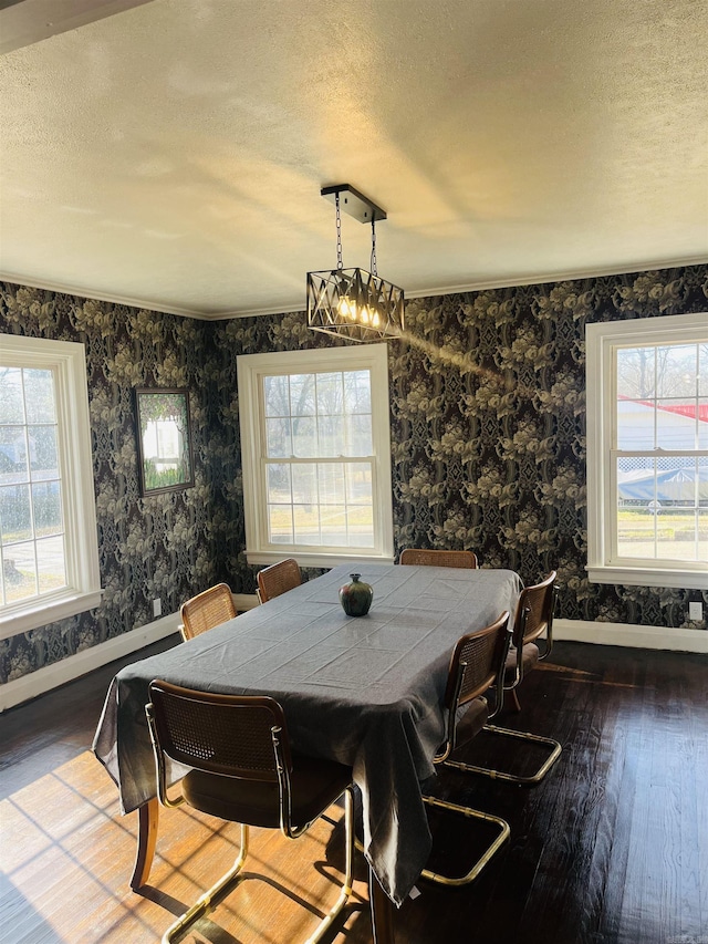 dining space featuring hardwood / wood-style flooring, ornamental molding, and a textured ceiling