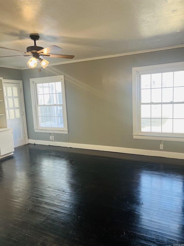 spare room featuring dark wood-type flooring, ceiling fan, and crown molding