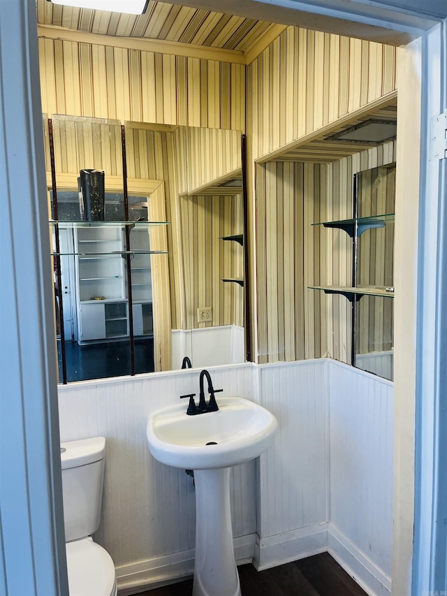 bathroom featuring hardwood / wood-style floors, toilet, and wooden walls