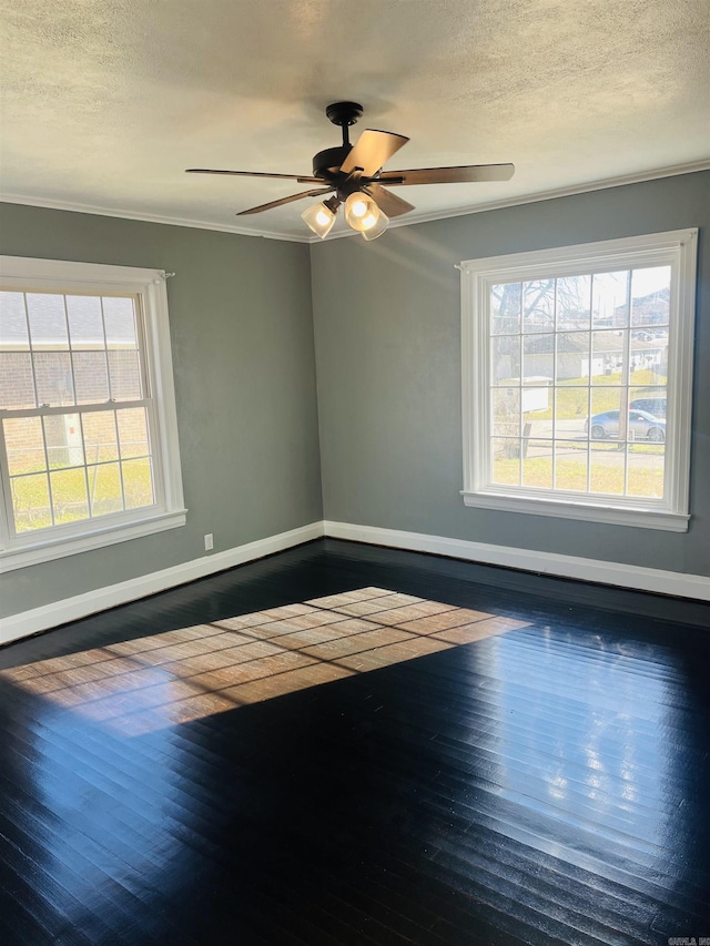 empty room with ceiling fan, dark hardwood / wood-style flooring, and ornamental molding