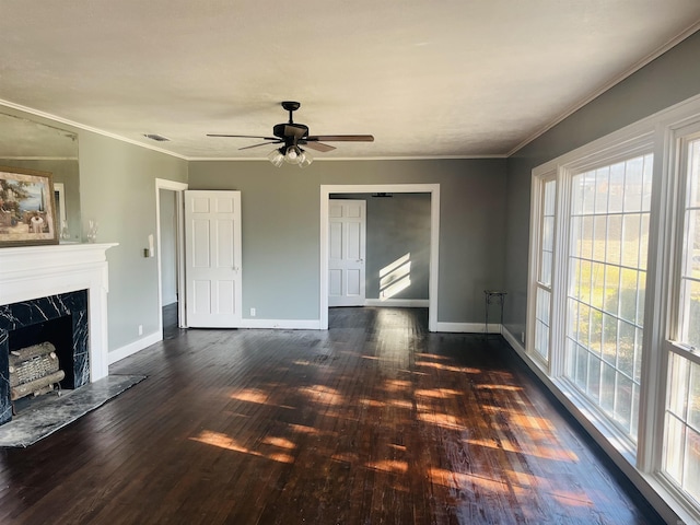 unfurnished living room with ornamental molding, ceiling fan, dark wood-type flooring, and a premium fireplace