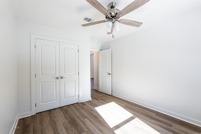 unfurnished bedroom with ceiling fan, light wood-type flooring, and a closet