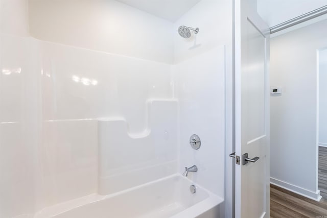 bathroom featuring hardwood / wood-style flooring and shower / washtub combination