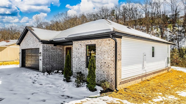 view of snow covered exterior featuring a garage