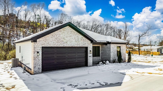 view of front of property featuring cooling unit and a garage