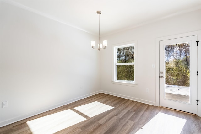 unfurnished dining area featuring wood-type flooring and an inviting chandelier