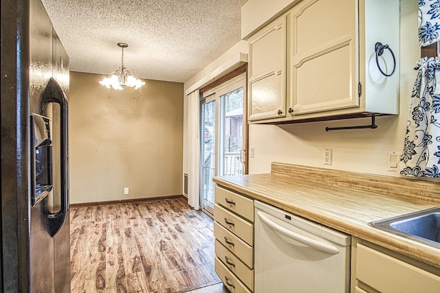 kitchen featuring pendant lighting, light hardwood / wood-style flooring, dishwasher, a textured ceiling, and black fridge with ice dispenser