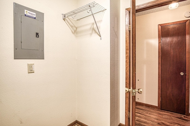 laundry room with electric panel and dark hardwood / wood-style floors