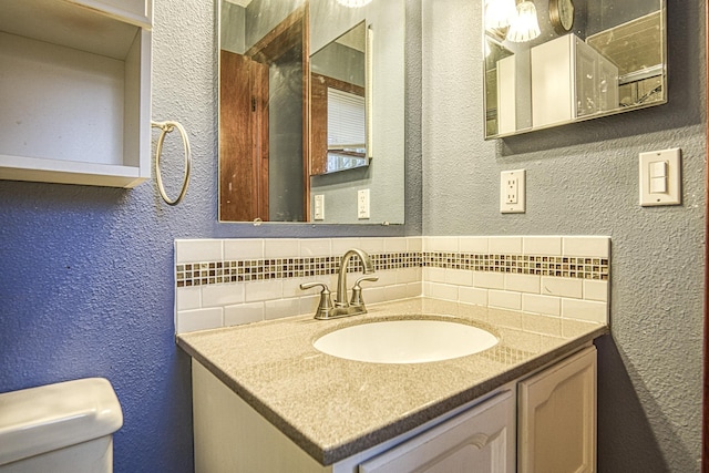 bathroom with tasteful backsplash, vanity, and toilet