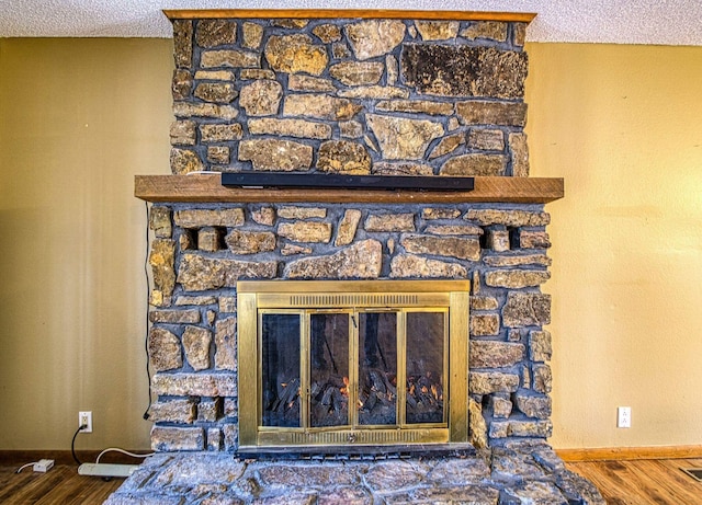 interior details with hardwood / wood-style flooring, a textured ceiling, and a fireplace