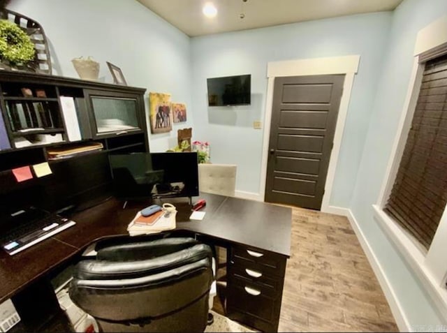 home office with light hardwood / wood-style floors