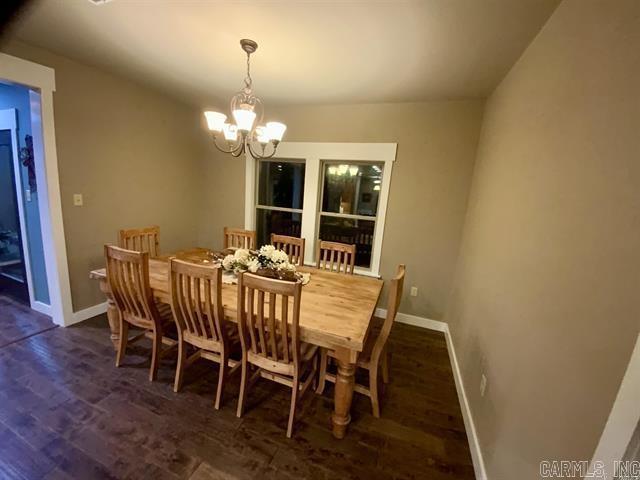 dining space featuring a notable chandelier and dark wood-type flooring