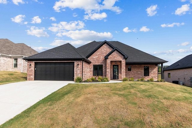 view of front of home featuring central AC, a front yard, and a garage