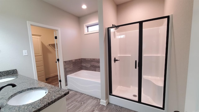 bathroom featuring wood-type flooring, vanity, and shower with separate bathtub