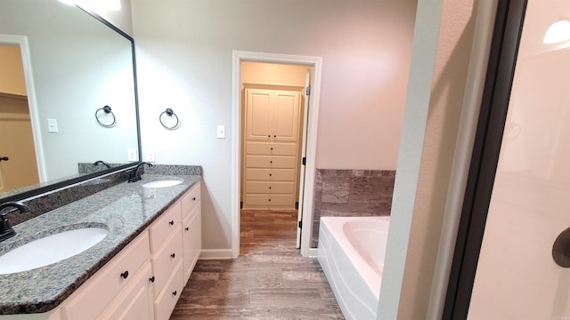 bathroom featuring hardwood / wood-style floors, vanity, and a bath