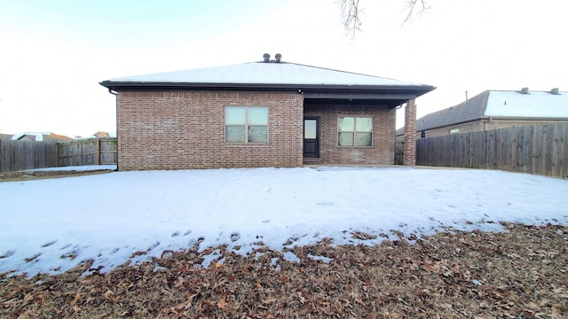 view of snow covered rear of property