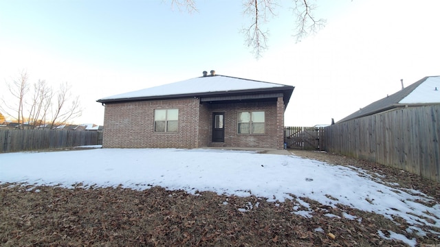 view of snow covered rear of property