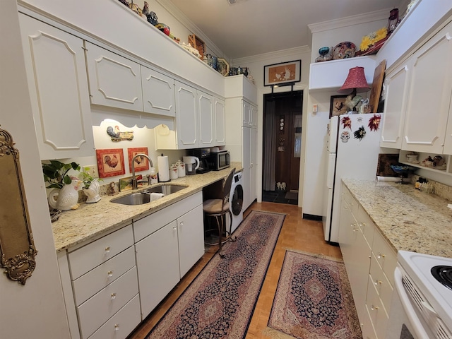 kitchen with white refrigerator, sink, light stone countertops, washer / dryer, and white cabinetry