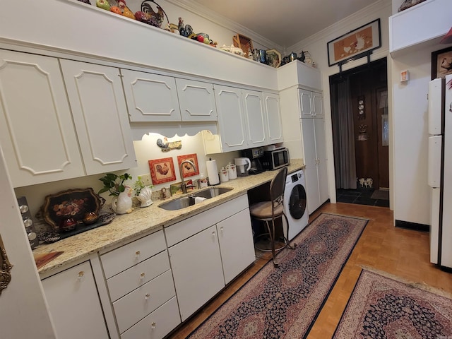 kitchen featuring white cabinetry, sink, washer / clothes dryer, crown molding, and light parquet flooring