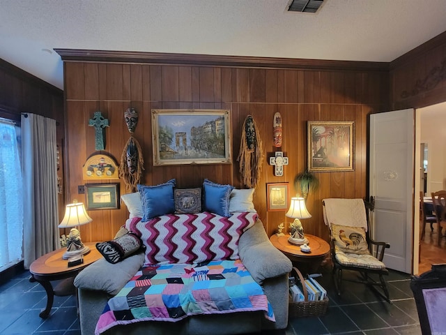 bedroom with wood walls, a textured ceiling, and ornamental molding