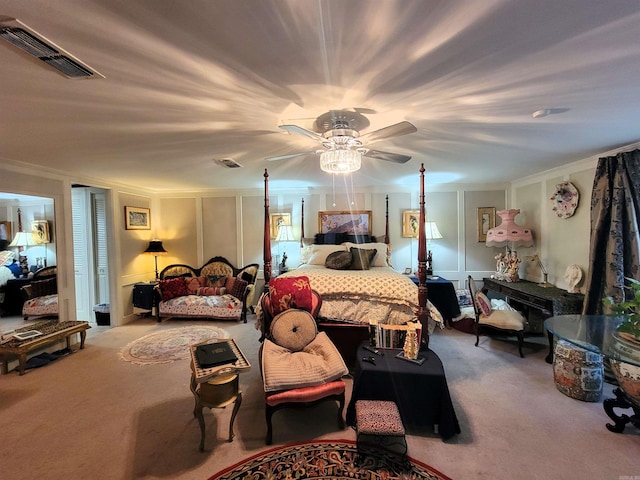 carpeted bedroom with ceiling fan and ornamental molding