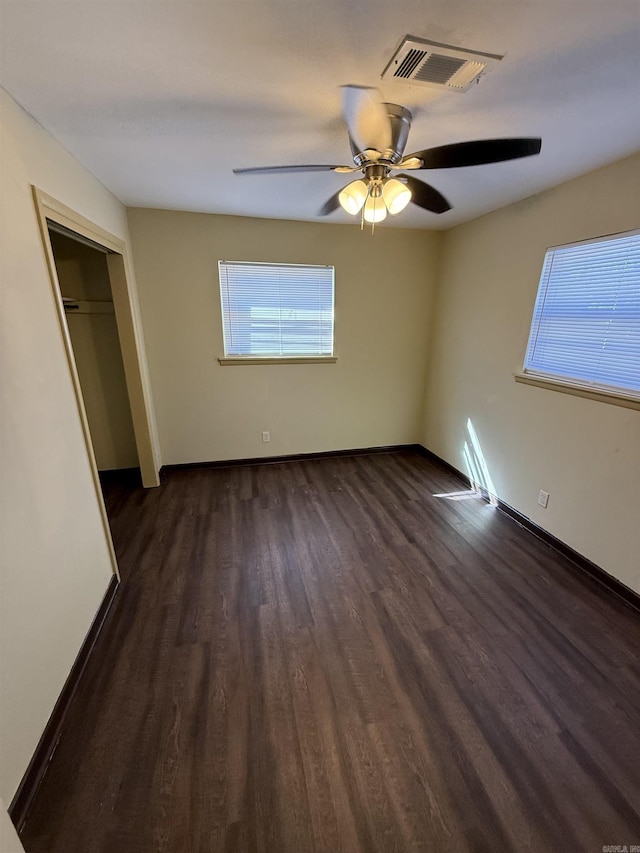 unfurnished bedroom featuring ceiling fan, a closet, and dark hardwood / wood-style floors