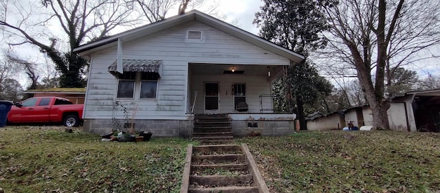 bungalow with a porch and a front lawn