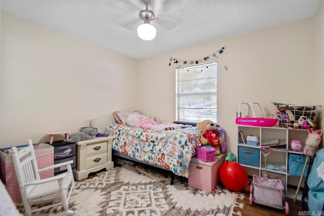 bedroom featuring ceiling fan, wood-type flooring, and a textured ceiling