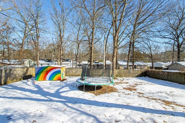 yard layered in snow featuring a trampoline