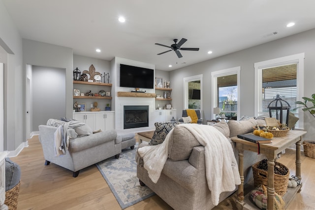 living room with light wood-type flooring and ceiling fan