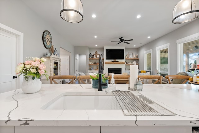 kitchen with light stone countertops and ceiling fan