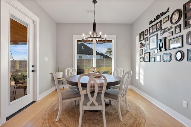 dining room featuring plenty of natural light, light hardwood / wood-style flooring, and an inviting chandelier