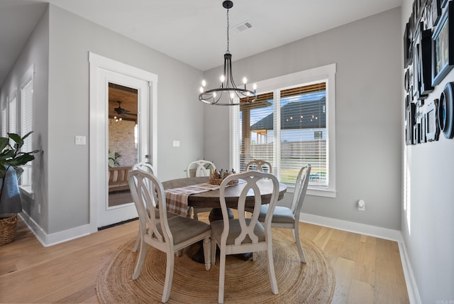 dining space with a notable chandelier and light wood-type flooring