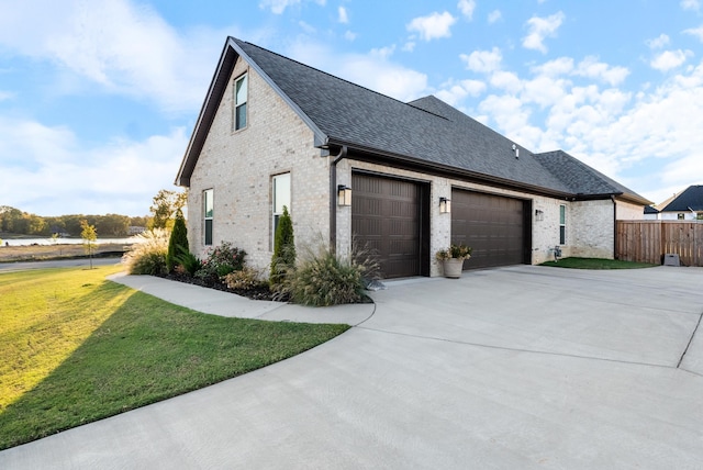 view of side of property with a garage and a lawn