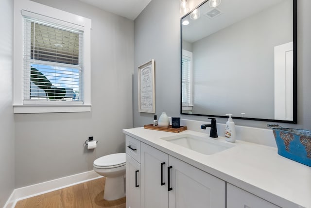 bathroom with hardwood / wood-style floors, vanity, and toilet