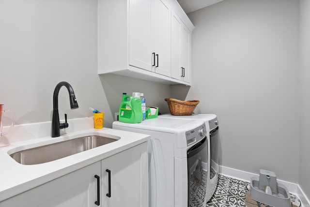 laundry room with tile patterned floors, separate washer and dryer, sink, and cabinets