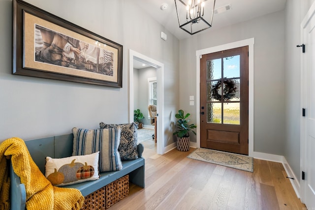 foyer featuring wood-type flooring and an inviting chandelier