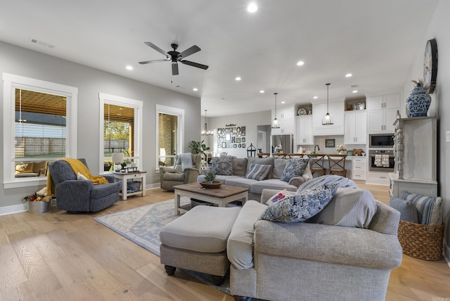 living room featuring ceiling fan and light wood-type flooring