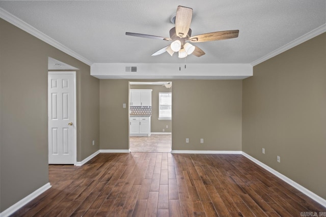 empty room featuring a textured ceiling, dark hardwood / wood-style floors, ceiling fan, and crown molding