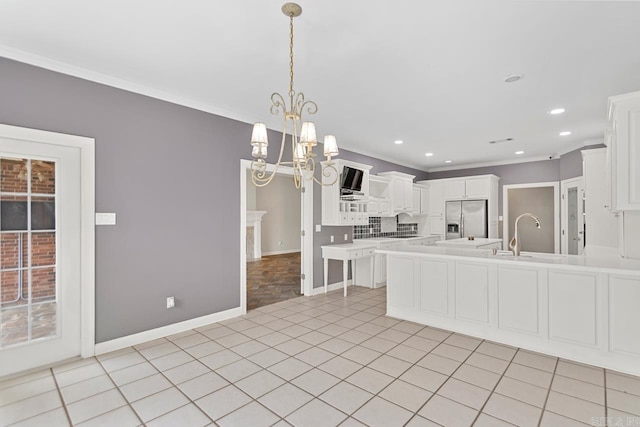 kitchen featuring an inviting chandelier, sink, stainless steel fridge with ice dispenser, light tile patterned floors, and white cabinetry