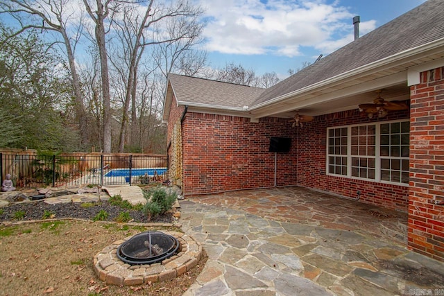 view of patio / terrace with a fenced in pool, ceiling fan, and a fire pit