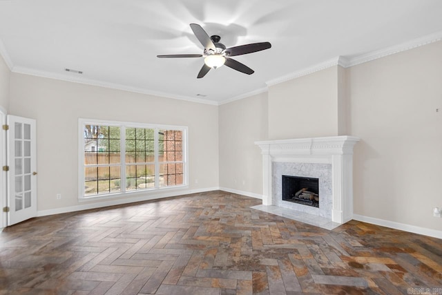 unfurnished living room featuring ceiling fan, a fireplace, dark parquet flooring, and crown molding