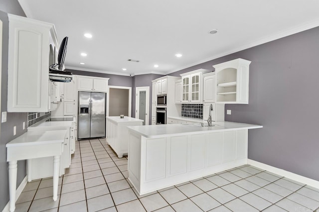 kitchen with crown molding, kitchen peninsula, light tile patterned floors, appliances with stainless steel finishes, and white cabinetry