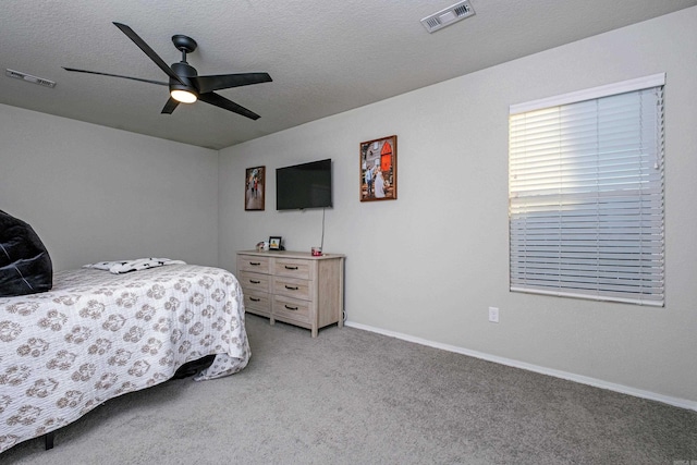 carpeted bedroom with ceiling fan and a textured ceiling