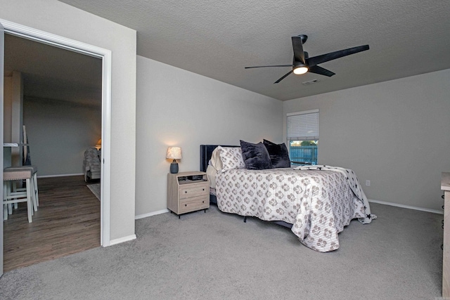 carpeted bedroom with ceiling fan and a textured ceiling